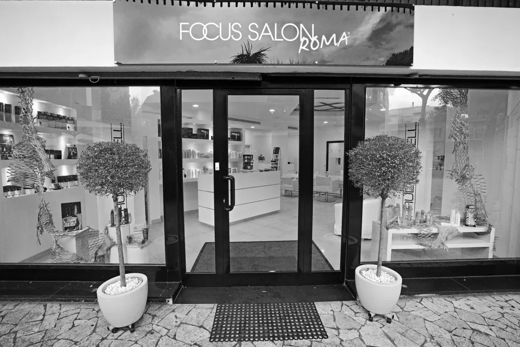 La vetrina di Focus Salon Roma in Viale Beethoven 55, con l'insegna e due alberelli in vaso